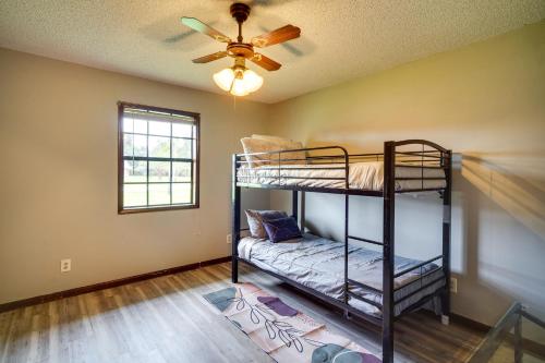 een kamer met 2 stapelbedden en een plafondventilator bij Charming Lake Charles Home with Patio and Grill in Lake Charles