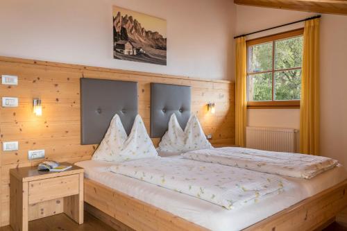 ein Schlafzimmer mit einem großen Bett und einer Holzwand in der Unterkunft Aurora Moarhof Natur Apartments in Lajen