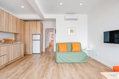 a living room with a couch with orange pillows on it at Belém River Apartment View in Lisbon