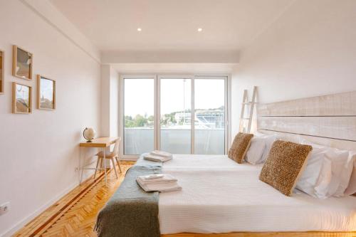 um quarto com uma cama grande e uma janela grande em Belém River Apartment View em Lisboa