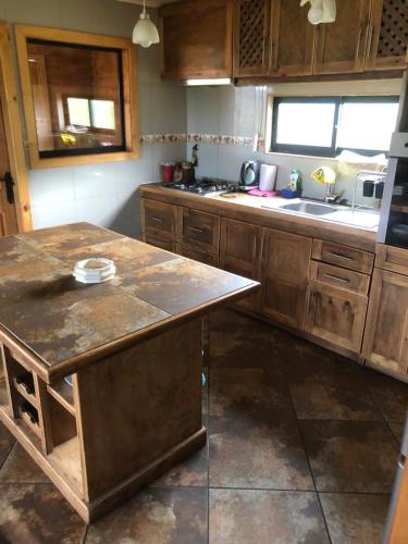 a kitchen with wooden cabinets and a counter top at CASAS Y CABAÑAS CUMBRES DEL SOL in Castro