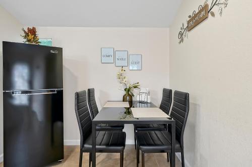 a dining room table with black chairs and a refrigerator at Charming Private Studio Near Raymond James Stadium in Tampa