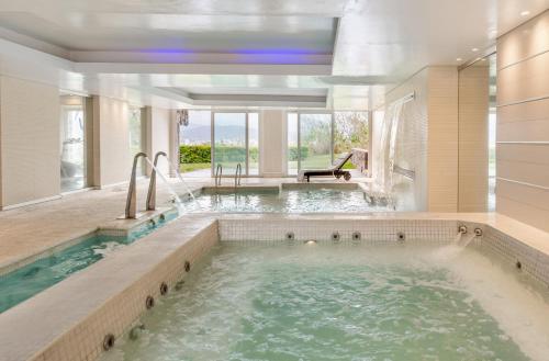uma banheira de hidromassagem num quarto amplo com uma janela grande em Hotel Altos de la Viña em San Salvador de Jujuy