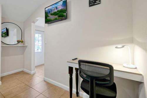 a desk with a chair and a monitor on a wall at Charming Private Studio Near Raymond James Stadium in Tampa