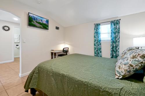a bedroom with a green bed and a window at Charming Private Studio Near Raymond James Stadium in Tampa