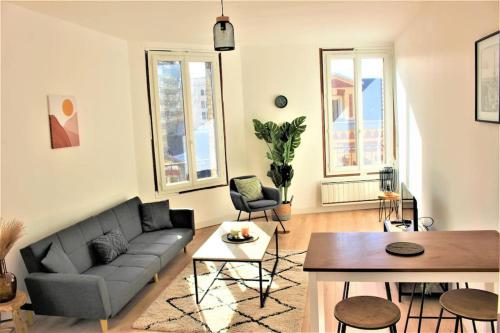 a living room with a couch and a table at Magnifique appartement in Le Havre
