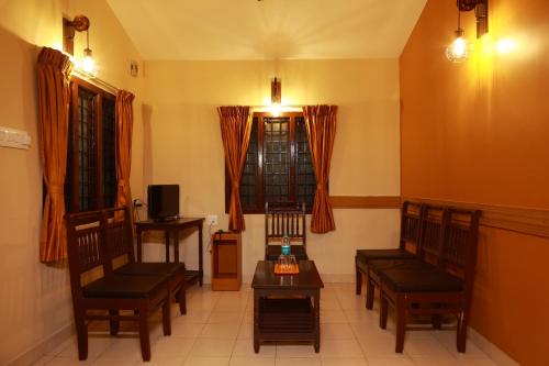 a living room with two chairs and a table at MM Resorts in Yercaud