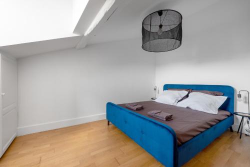 Una cama azul en una habitación con paredes blancas. en T3 Duplex - Vue sur toits & Cité en Carcasona