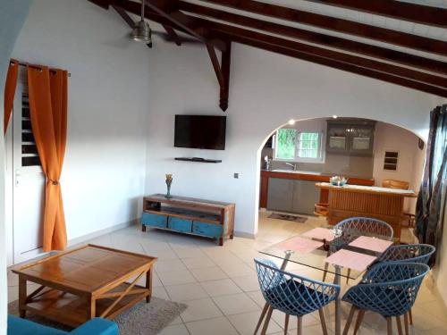 a living room with a table and a kitchen at Maison charmante avec piscine à Petit-Bourg. in Petit-Bourg