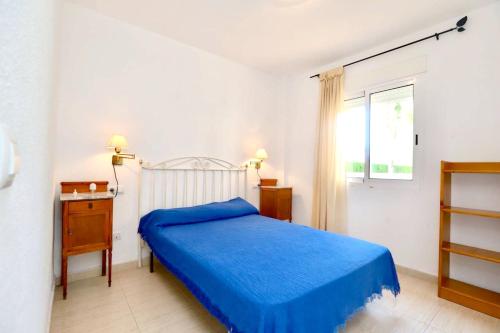 - une chambre avec un lit bleu et une fenêtre dans l'établissement 2 bedrooms apartement at Denia 300 m away from the beach with shared pool and furnished terrace, à Dénia