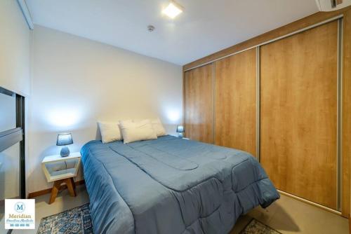een slaapkamer met een groot bed en een houten kast bij Tribeca del Sol - 501 in Asuncion
