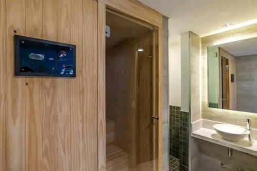 een badkamer met een wastafel en een tv aan de muur bij Tribeca del Sol - 501 in Asuncion
