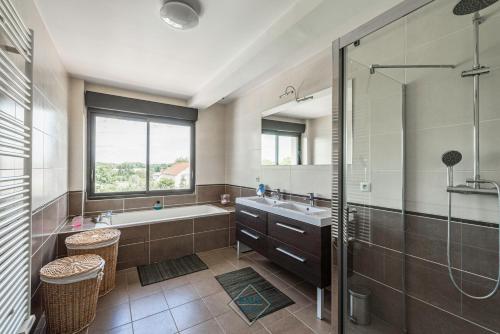 une salle de bain avec une baignoire, un lavabo et une douche dans l'établissement Luxury villa near Disneyland Bmyguest, à Gouvernes