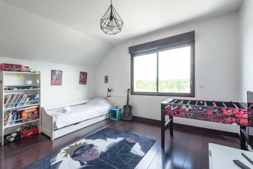 une chambre avec un lit, un bureau et une fenêtre dans l'établissement Luxury villa near Disneyland Bmyguest, à Gouvernes