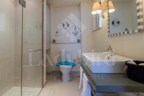 a bathroom with a toilet and a sink and a shower at Ladybird - Veranda Beach House in Hurghada