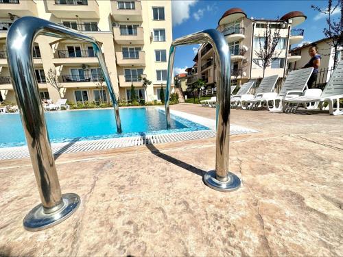 a pool with two metal bars in front of a building at Ipanema Beach - Menada Apartments in Sveti Vlas
