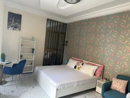 um quarto com uma cama e uma parede com papel de parede floral em Le doux refuge em Dakar