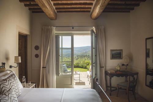 a bedroom with a bed and a door to a patio at Castello di Casole, A Belmond Hotel, Tuscany in Casole dʼElsa