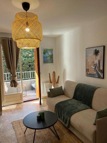 a living room with a couch and a table at Petit paradis Portissol 400m plage/commerces in Sanary-sur-Mer