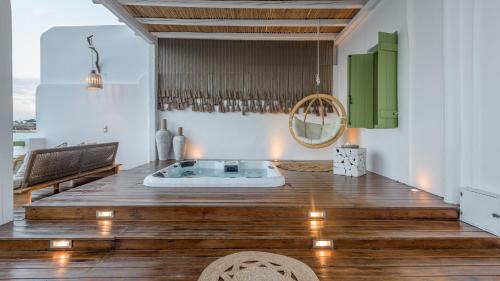 um quarto com uma banheira de hidromassagem num piso de madeira em villa lord em Pollonia