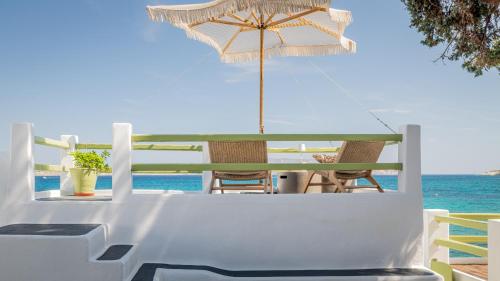 a table with an umbrella and chairs and the ocean at villa lord in Pollonia