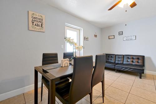 a dining room with a table and chairs and a couch at JetPad Tampa Modern studio near Busch Gardens & Airport in Tampa
