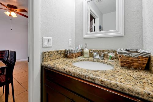 a bathroom counter with a sink and a mirror at Modern Studio Near Busch Gardens Tampa in Tampa
