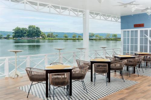 a restaurant with tables and chairs and a view of the water at Hotel Casona del Lago in Flores