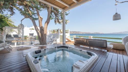 a hot tub on a deck with a view of the ocean at villa lord in Pollonia