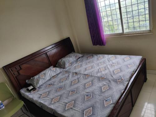 an empty bed in a bedroom with a window at Aayushman Homes in Bangalore