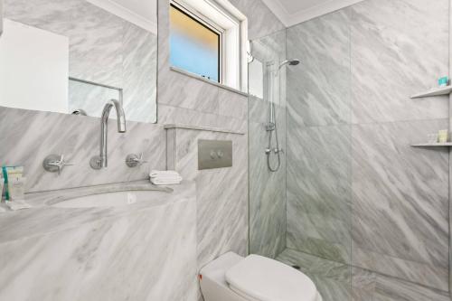 a bathroom with a toilet and a sink and a mirror at Northern Beaches Surfer's Sanctuary Studio in Deewhy