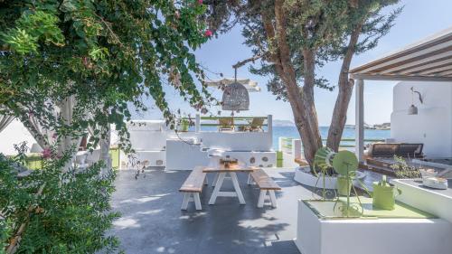 a patio with a picnic table and trees and the ocean at villa lord in Pollonia