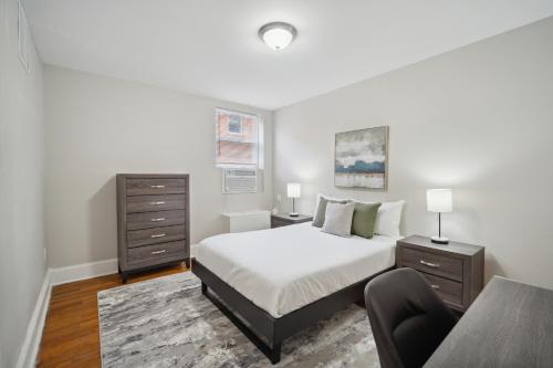 a white bedroom with a bed and a chair at Peaceful & Perfect Private 1-br I Lennox in Philadelphia