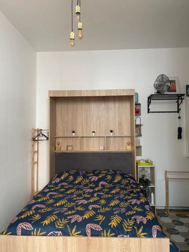 Schlafzimmer mit einem Bett mit einem großen Kopfteil in der Unterkunft Music Box from 10 mn Paris centre in Saint-Ouen