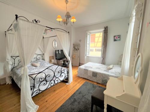 a bedroom with two beds and a mirror at GITE AU COEUR DU VIGNOBLE ALSACIEN in Ribeauvillé