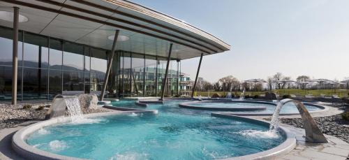 une piscine avec deux fontaines devant un bâtiment dans l'établissement GITE AU COEUR DU VIGNOBLE ALSACIEN, à Ribeauvillé