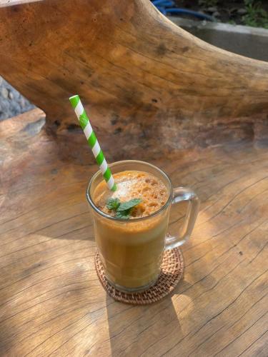 a cup of coffee sitting on a wooden table at Happy Spiritus Guethouse Tabanan in Tabanan