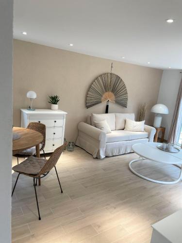 a living room with a white couch and a table at Moderner Bungalow im Seebad Bansin, 200 Meter zum Strand in Bansin