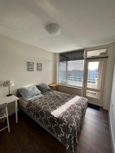 Apartment with city skyline في ليوواردن: غرفة نوم بسرير ومكتب ونافذة
