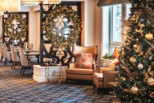 a christmas tree in a hotel lobby with christmas decorations at Fairmont Château Lake Louise in Lake Louise