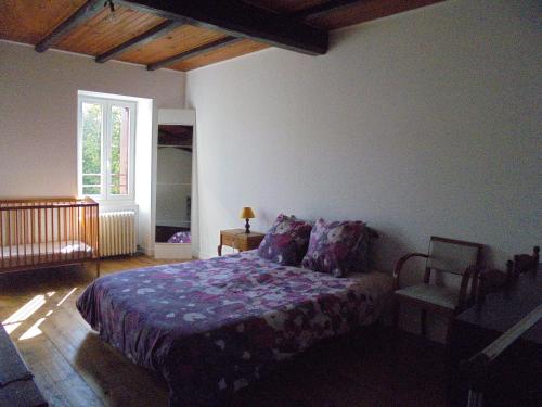 sypialnia z łóżkiem z fioletowym kocem i oknem w obiekcie Logement chez l'habitant! w mieście Condéon
