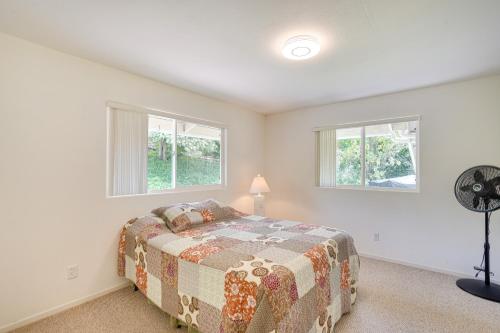 a bedroom with a bed and two windows at Captain Cook Home on Quiet 3 Acres with Fruit Trees in Papa Bay Estates