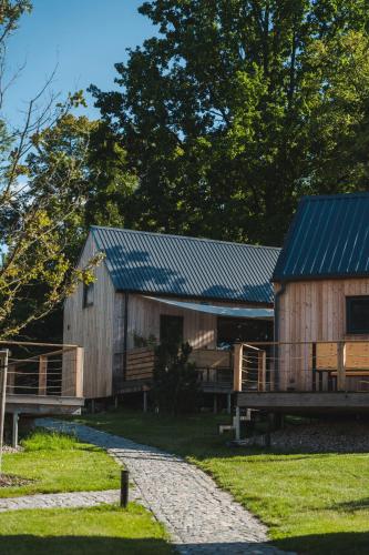 a large wooden cabin with a blue roof at PRIMÁTOR CAMPING RESORT LITOMYŠL in Litomyšl