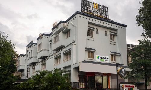 a white building with a balcony on top of it at Treebo Prasha in Nashik