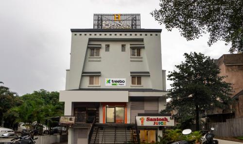 a tall white building with a staircase in front of it at Treebo Trend Prasha in Nashik