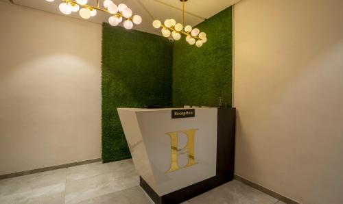 a room with a green wall with a sign on it at Treebo Prasha in Nashik