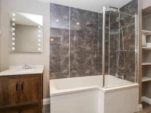 a bathroom with a shower with a tub and a sink at 19 Lion Street in Hereford