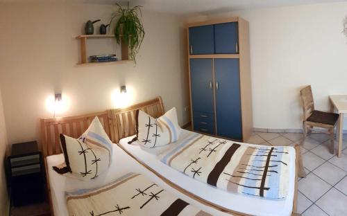 1 Schlafzimmer mit 2 Betten und einem blauen Schrank in der Unterkunft Ruhige Ferienwohnung in Niepars in Niepars