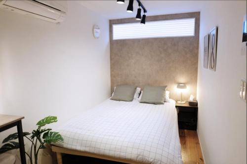 a bedroom with a white bed and a window at 夢の舎 Asakusa Horizon Bleu in Tokyo