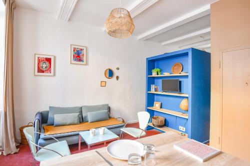 un salon avec un canapé bleu et une table dans l'établissement Studio L'Académie - Vieux Port & Cours Julien, à Marseille